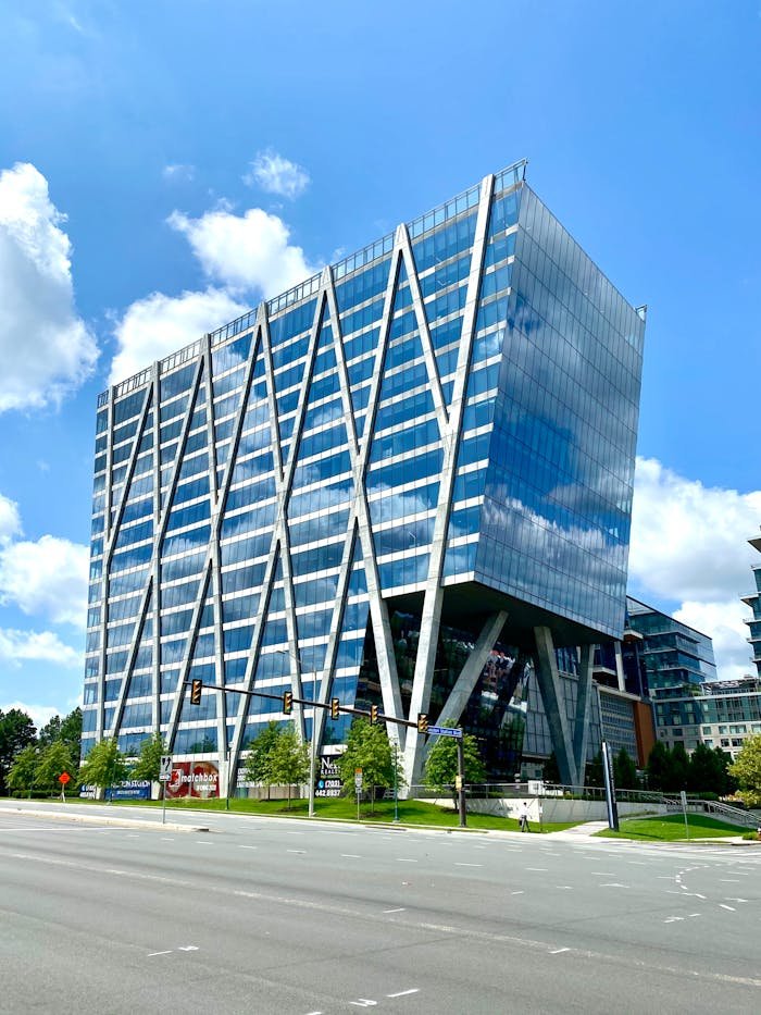 about-02 A striking modern office building with a geometric glass facade in an urban setting.